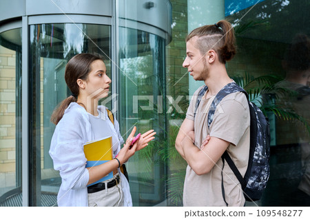Meeting of two teenage students, guy and girl, near educational building 109548277