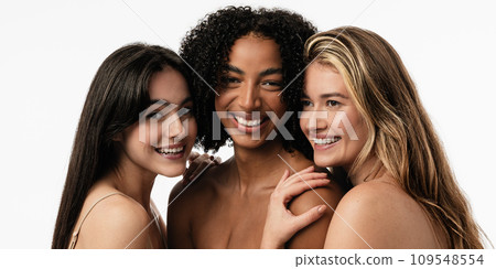 Female models of different ages celebrating their natural bodies in a studio. Three confident and happy women smiling cheerfully. Women standing together against a studio background. 109548554