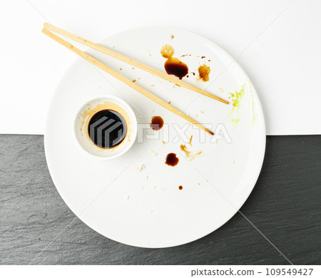 Dirty Sushi Plate on Black Table, Empty Bowl after Sushi Dinner, Finished Asian Lunch, Salad and Wasabi Sauce 109549427