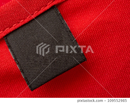 Blank black laundry care clothes label on red fabric texture background Blank black laundry care clothes label on red fabric texture background 109552985