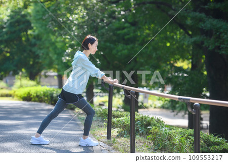 Woman doing warm-up exercise stretching Woman doing warm-up exercise stretching 109553217