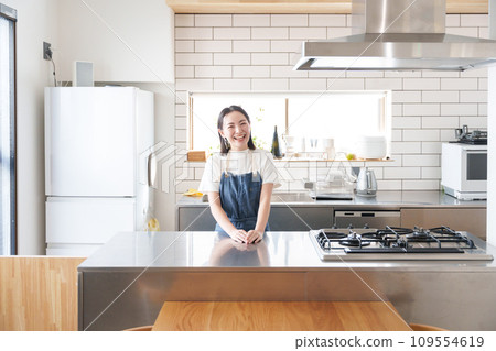 Smiling woman cooking in the kitchen Smiling woman cooking in the kitchen 109554619