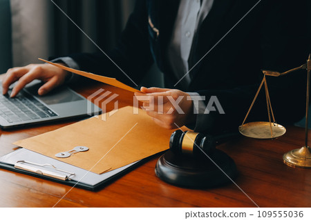 Business and lawyers discussing contract papers with brass scale on desk in office. Law, legal services, advice, justice and law concept picture with film grain effect Business and lawyers discussing contract papers with brass scale on desk in office. Law, legal services, advice, justice and law concept picture with film grain effect 109555036