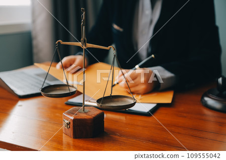 Business and lawyers discussing contract papers with brass scale on desk in office. Law, legal services, advice, justice and law concept picture with film grain effect Business and lawyers discussing contract papers with brass scale on desk in office. Law, legal services, advice, justice and law concept picture with film grain effect 109555042