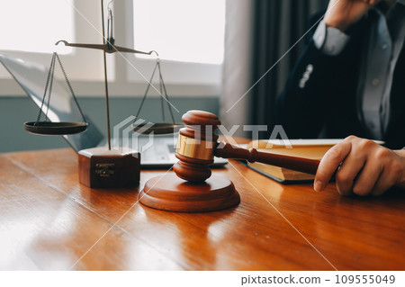 Business and lawyers discussing contract papers with brass scale on desk in office. Law, legal services, advice, justice and law concept picture with film grain effect Business and lawyers discussing contract papers with brass scale on desk in office. Law, legal services, advice, justice and law concept picture with film grain effect 109555049