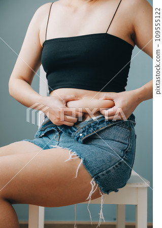 fat woman, fat belly, chubby, obese woman hand holding excessive belly fat with measure tape, woman diet lifestyle concept 109555122