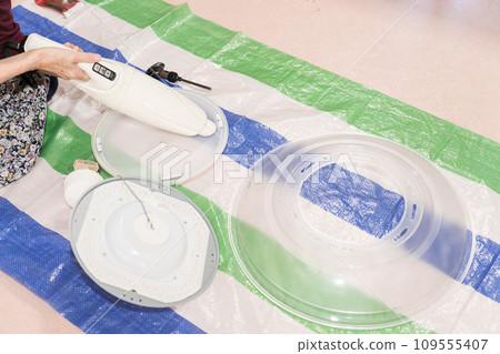 Parts cut of a senior woman cleaning lighting equipment Parts cut of a senior woman cleaning lighting equipment 109555407