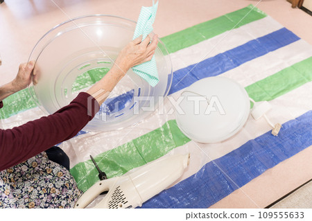 Parts cut of a senior woman cleaning lighting equipment Parts cut of a senior woman cleaning lighting equipment 109555633