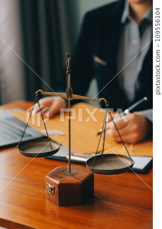 Business and lawyers discussing contract papers with brass scale on desk in office. Law, legal services, advice, justice and law concept picture with film grain effect Business and lawyers discussing contract papers with brass scale on desk in office. Law, legal services, advice, justice and law concept picture with film grain effect 109556104