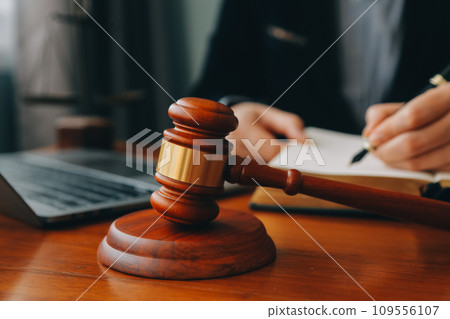 Business and lawyers discussing contract papers with brass scale on desk in office. Law, legal services, advice, justice and law concept picture with film grain effect Business and lawyers discussing contract papers with brass scale on desk in office. Law, legal services, advice, justice and law concept picture with film grain effect 109556107
