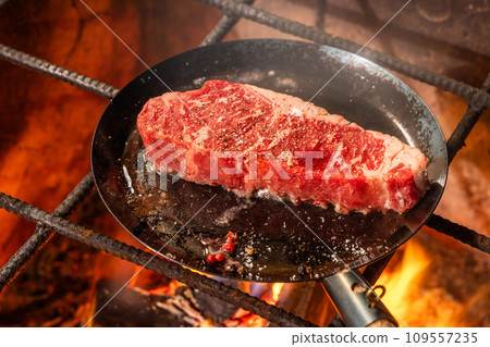 Grill a steak over an outdoor 109557235