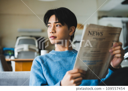 一個20多歲的年輕人看報紙的肖像 109557454
