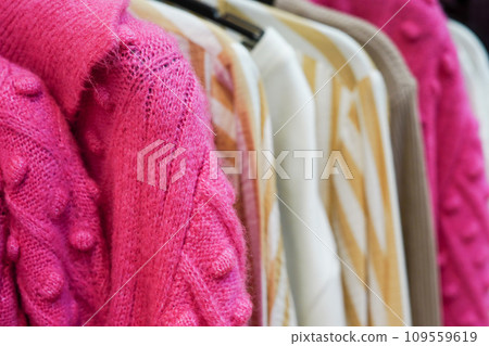 Stylish warm colorful clothes on hangers in the store 109559619