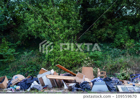 Illegal garbage dump near the green forest. environmental pollution problem excessive consumption Illegal garbage dump near the green forest. environmental pollution problem excessive consumption 109559670