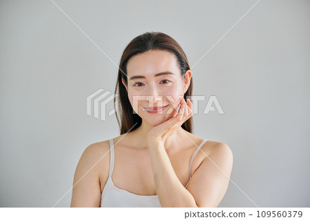 A woman in her 30s taking care of her skin by massaging her face 109560379
