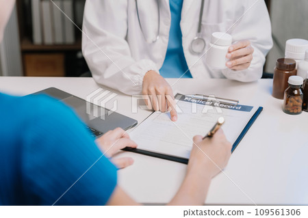 patient filling insurance legal document at appointment with doctor. patient signing medical treatment contract, agreement form for taking medic care service, consultation, therapy patient filling insurance legal document at appointment with doctor. patient signing medical treatment contract, agreement form for taking medic care service, consultation, therapy 109561306