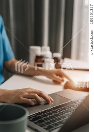 Doctor physician with stethoscope calculate medical fee costs & revenue. practitioner use calculator at clinic in the morning. 109561337