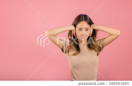 Asian portrait beautiful young woman have close ears with hand palms and close eyes, studio shot isolated on pink background, Thai female covering ears for loud noise with copy space, bad pressure Asian portrait beautiful young woman have close ears with hand palms and close eyes, studio shot isolated on pink background, Thai female covering ears for loud noise with copy space, bad pressure 109561693