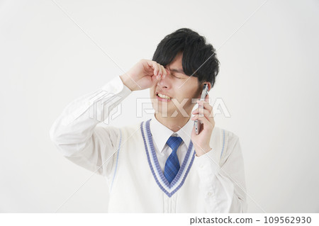 High school boy crying while calling on smartphone, white background High school boy crying while calling on smartphone, white background 109562930