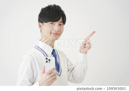 High school boy holding a smartphone and pointing to the right, white background High school boy holding a smartphone and pointing to the right, white background 109563001