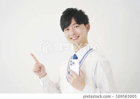 高中男孩拿著智慧型手機，指著左邊，白色背景 109563005