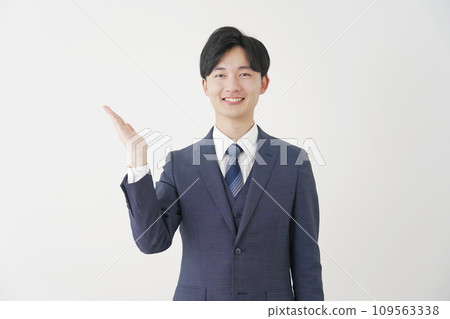 一個商人用他的手掌在白色背景上指向左邊 109563338