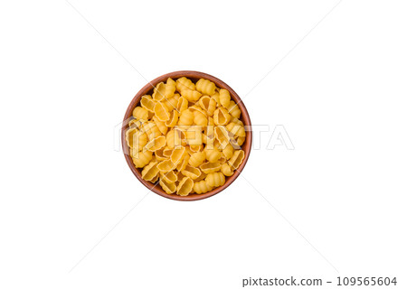 Raw durum wheat gnocchi pasta with salt and spices in a ceramic plate Raw durum wheat gnocchi pasta with salt and spices in a ceramic plate 109565604