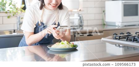 一位女士用智慧型手機拍攝食物照片 一位女士用智慧型手機拍攝食物照片 109566173