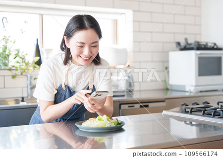 一位女士用智慧型手機拍攝食物照片 一位女士用智慧型手機拍攝食物照片 109566174