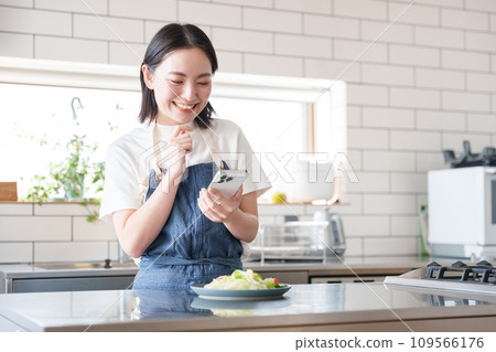 一位女士用智慧型手機拍攝食物照片 109566176