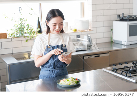 A woman taking pictures of food with a smartphone A woman taking pictures of food with a smartphone 109566177