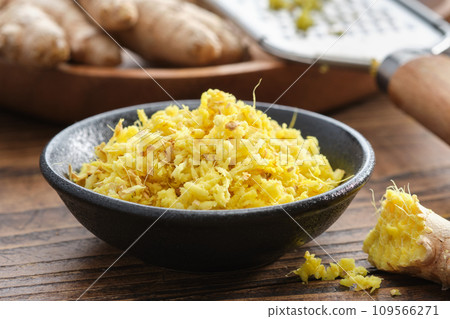 Bowls of grated fresh ginger roots. Whole ginger roots and grater on background. Healthy food. Ingredients for cooking and Ayurveda. 109566271