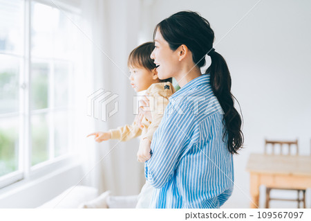 Parent and child hugging each other and looking outside 109567097