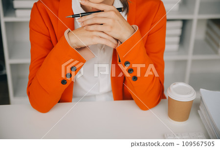 Attractive smiling young asian business woman work at home office, Asian woman working on laptop computer holding tablet. 109567505