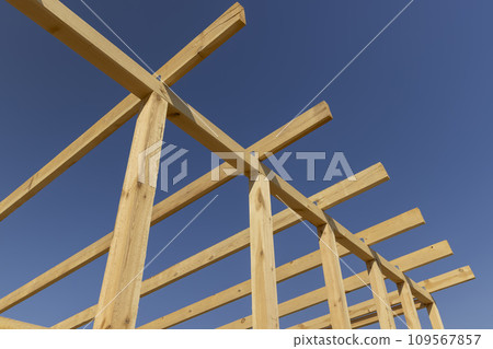 the wooden frame of the building against the blue sky the wooden frame of the building against the blue sky 109567857