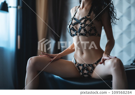 sexy striptease woman in black leather harness Stock Photo