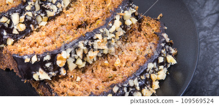 Pieces of zucchini dough with nuts and raisins on black plate Pieces of zucchini dough with nuts and raisins on black plate 109569524