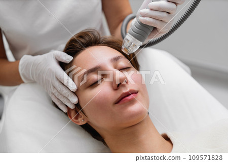 A cosmetologist performs hydropiling in a beauty salon. Skin care. A cosmetologist performs hydropiling in a beauty salon. Skin care. 109571828