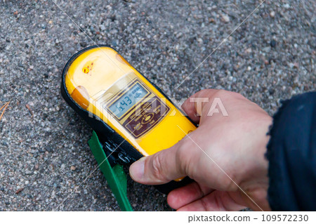 Male hand holding a dosimeter. Measurement of radiation levels by the Geiger counter in Chernobyl Exclusion Zone, Ukraine 109572230