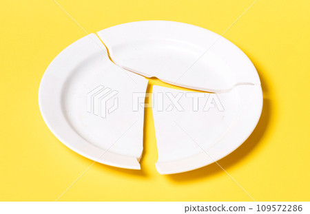 Broken white plate on a solid background Broken white plate on a solid background 109572286