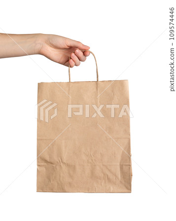 Hand holding paper bag, kraft brown packet mockup isolated on white background Hand holding paper bag, kraft brown packet mockup isolated on white background 109574446