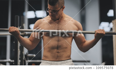 Young Arab man pumping biceps in the gym. Young Arab man pumping biceps in the gym. 109575078