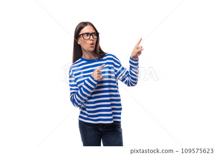 portrait of a European pretty brunette young lady in a casual striped sweater and jeans on a white 109575623