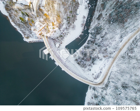 Sec water reservoir with concrete dam and wintertime snowy hills of Iron Mountains around. Czechia. Aerial view from drone. 109575765