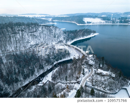Sec water reservoir with concrete dam and wintertime snowy hills of Iron Mountains around. Czechia. Aerial view from drone. 109575766