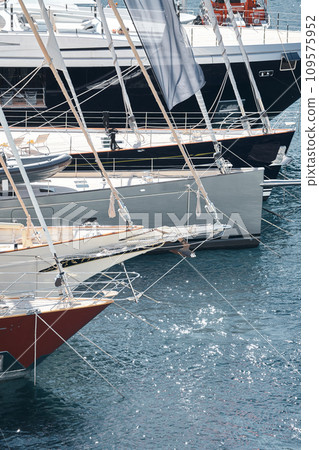 Sun glare on glossy board boats, azure water, tranquillity in port Hercules, bows of moored sailing boats at sunny day, megayachts, Monaco, Monte-Carlo 109575952
