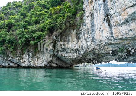 越南:一個人在奇岩怪石環繞的下龍灣劃著獨木舟,到達一個旅遊景點。 越南:一個人在奇岩怪石環繞的下龍灣劃著獨木舟,到達一個旅遊景點。 109579233