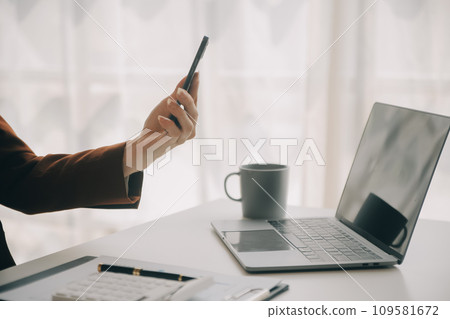 Close up Business woman using calculator and laptop for do math finance on wooden desk, tax, accounting, statistics and analytical research concept 109581672