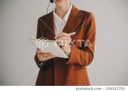Beautiful female call center operator working on computer in office Beautiful female call center operator working on computer in office 109581703