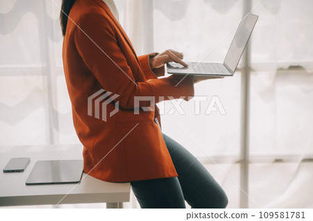 Close up Business woman using calculator and laptop for do math finance on wooden desk, tax, accounting, statistics and analytical research concept 109581781
